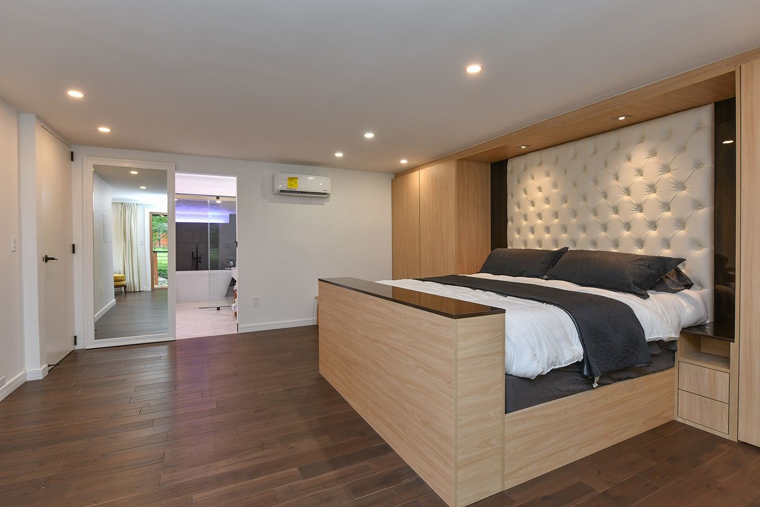 Custom built-in bed suite with oak surround and tufted headboard
