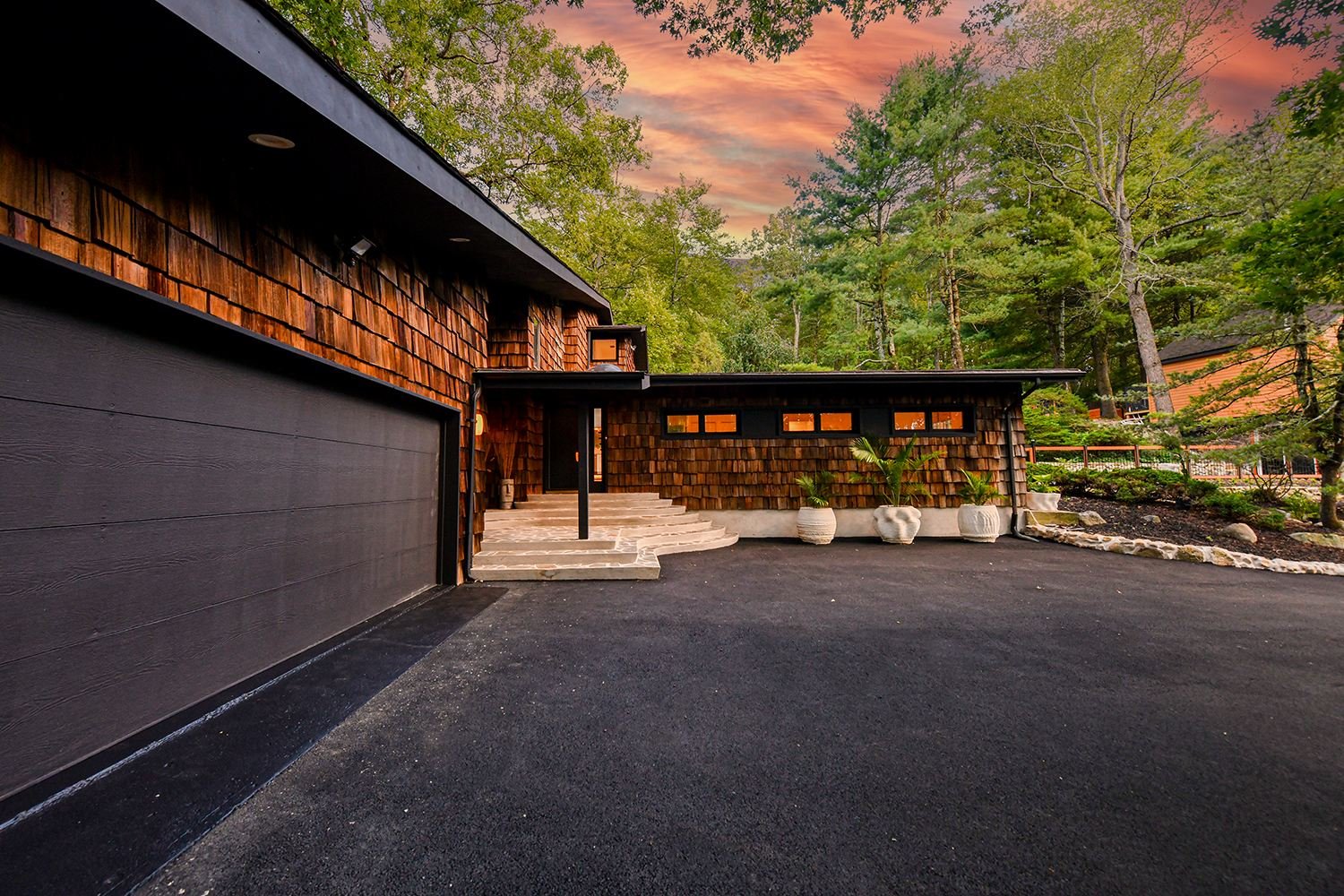 Renovated cedar shake home exterior at dusk with black accents