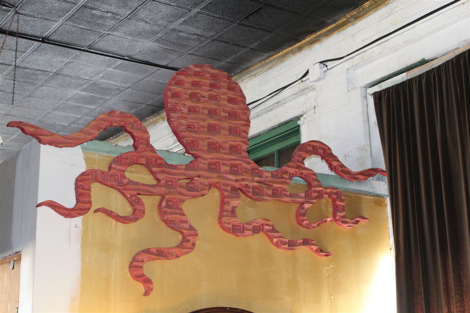 Giant carved octopus sculpture wrapping over a restaurant doorway