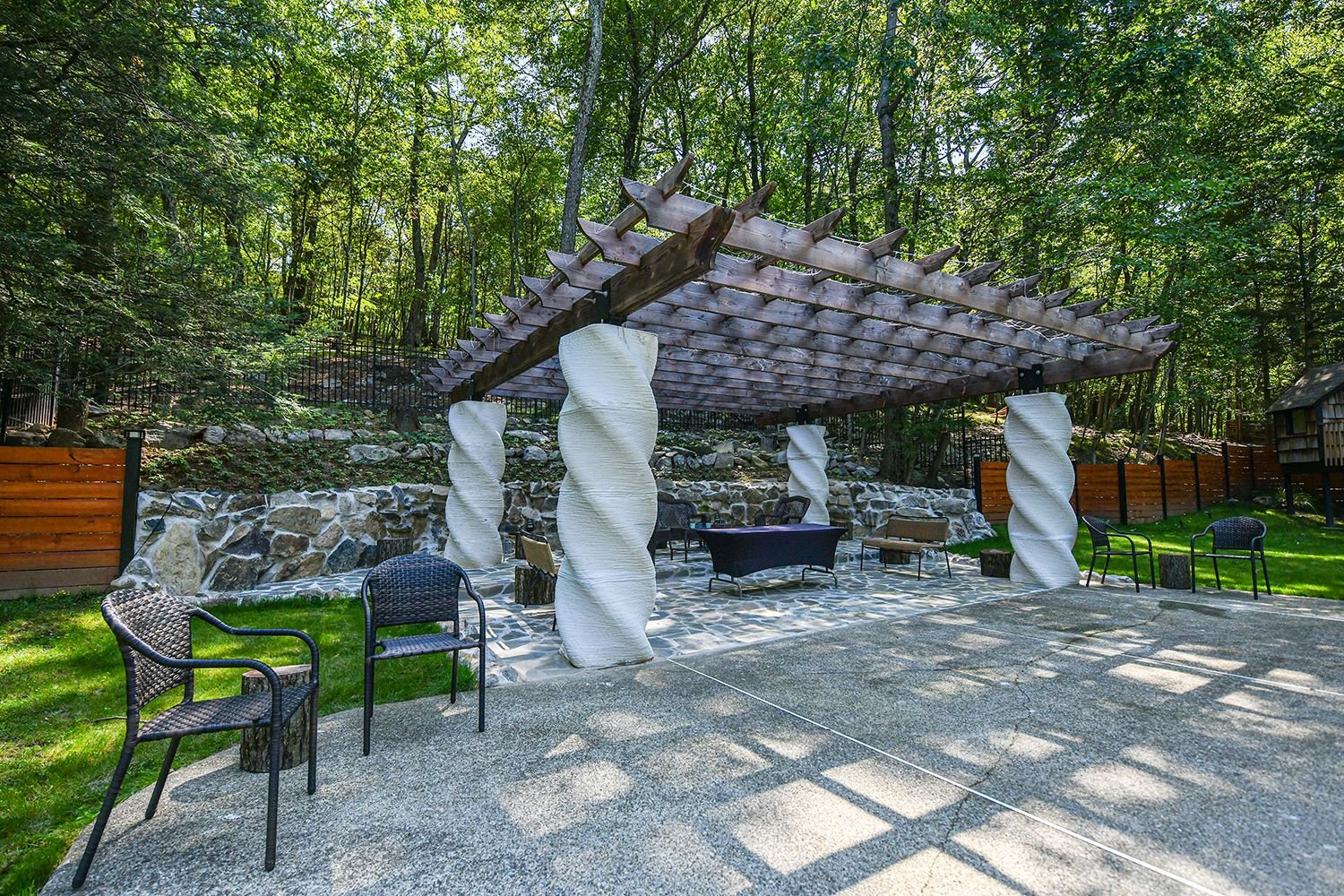 The finished custom pergola with sculpted rafter tails, built poolside