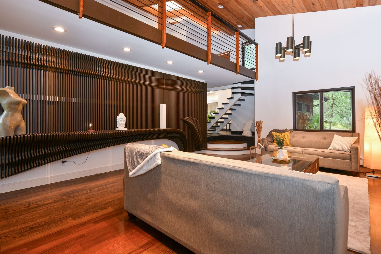 CNC-machined parametric wave wall spanning a two-story living room, built and installed by Marco Designs CNC